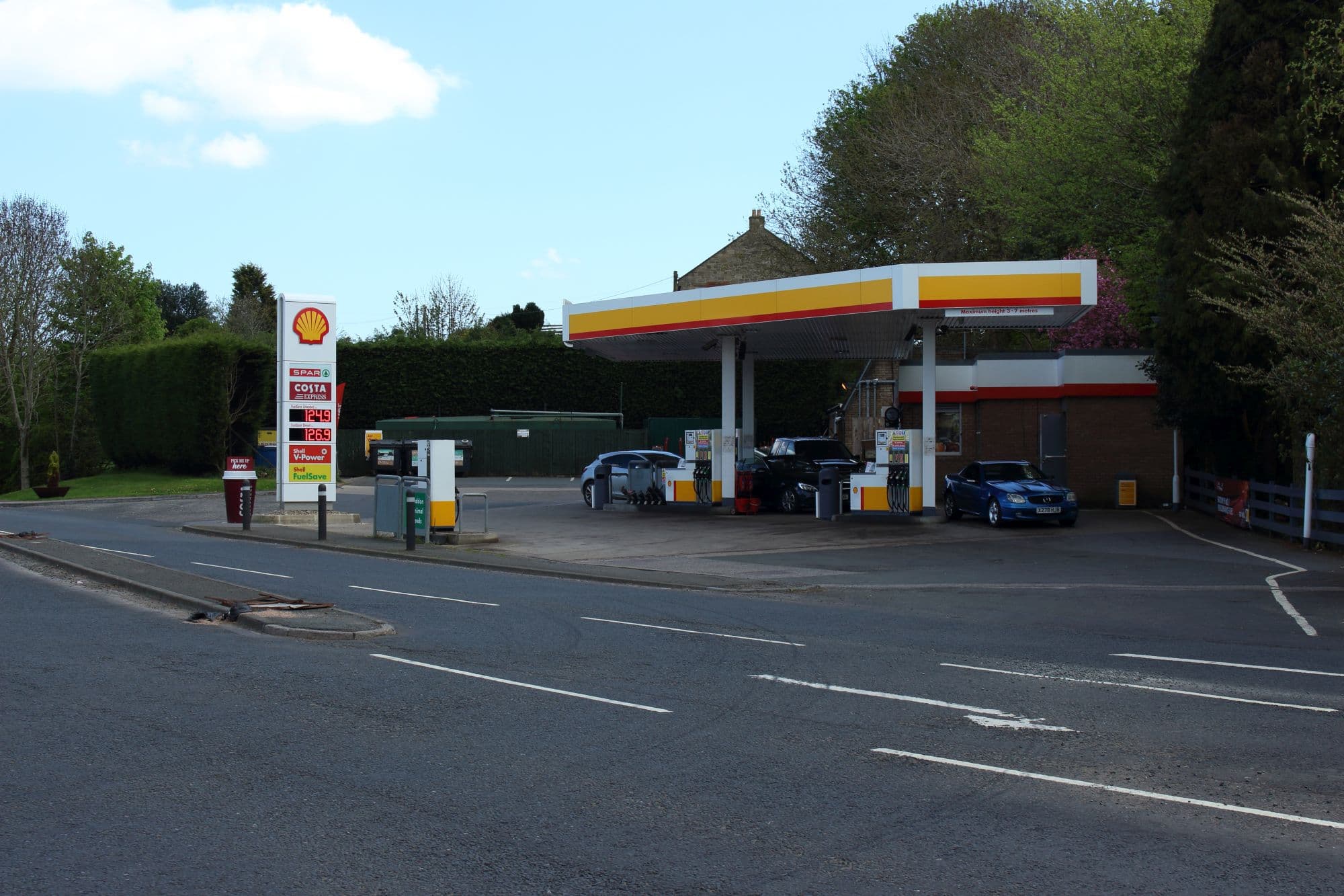 A Shell petrol station forecourt in Heddon-on-the-Wall, Northumberland, England, showing the price totem and fuel pumps under the canopy.